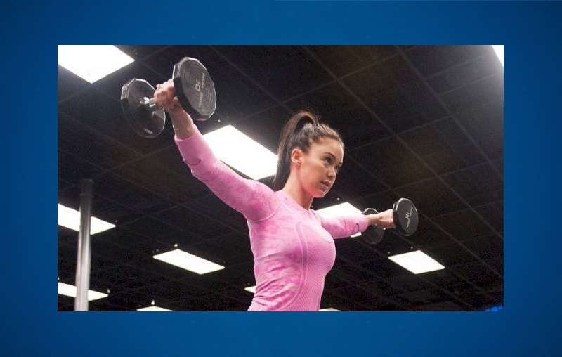 Fitness model Katy Hearn lifting dumbbells.
